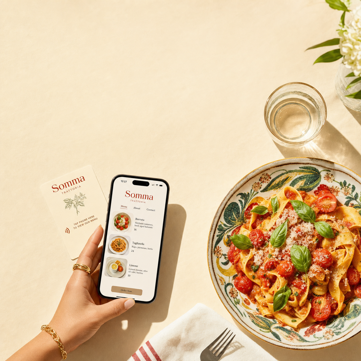 A hand tapping a phone to an NFC card next to a beautiful pasta dish